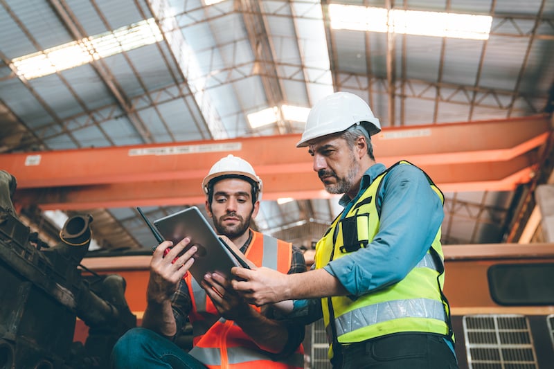 maintenance manager showing a operation and maintenance manual to a new hire