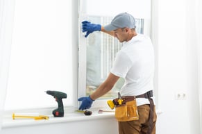 worker performing scheduled maintenance on window